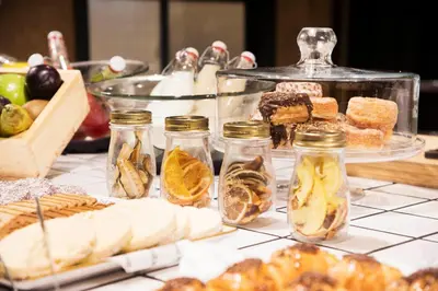 a table topped with jars of food and desserts at The Corner Hotel in Barcelona