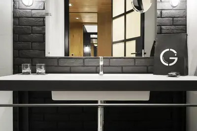 a bathroom sink with a mirror and two glasses on it at The Corner Hotel in Barcelona