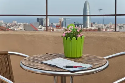 a table with a vase of flowers and a pen at Hotel Everest in Barcelona