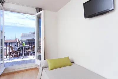 a living room with a couch and a large window at Hotel Everest in Barcelona