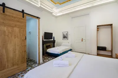 a room with two beds and a tv and a fireplace at Hostal Girona in Barcelona