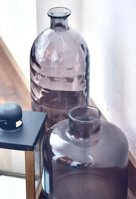 a glass jar and a large glass vase on a table at Hostal Girona in Barcelona