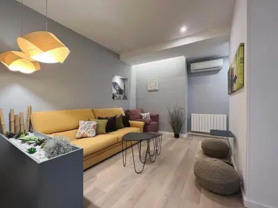 a living room with a yellow couch and a table at Stay U-nique Apartments Sants in Barcelona