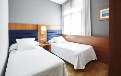 a hotel room with two beds and a window at Barcelona Century Hotel in Barcelona