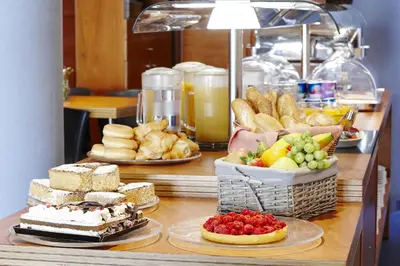 a buffet with different types of bread and desserts at Barcelona Century Hotel in Barcelona