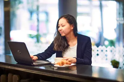 a woman sitting at a table with a laptop computer at Barcelona Century Hotel in Barcelona