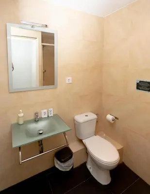 a bathroom with a toilet and a sink and a mirror at Easy Sants by Bossh! Hotels in Barcelona