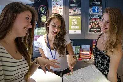 two women standing in a store looking at a map at Sant Jordi Hostels Sagrada Familia in Barcelona