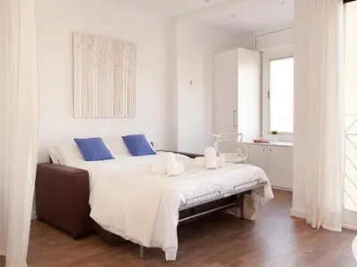 a white bedroom with two beds with blue pillows at Stay U-nique Apartments Sant Pau in Barcelona
