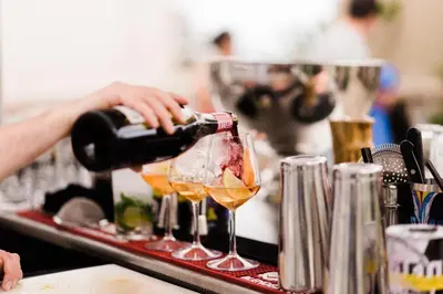 a person pouring wine into a wine glass at Room Mate Anna, Barcelona in Barcelona