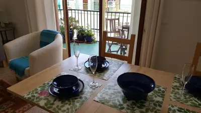 a wooden table with glasses and plates on top of it at Apartamento Hector en Sitges in Sitges