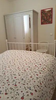 a bedroom with a bed with a floral bedspread on it at Apartamento Hector en Sitges in Sitges