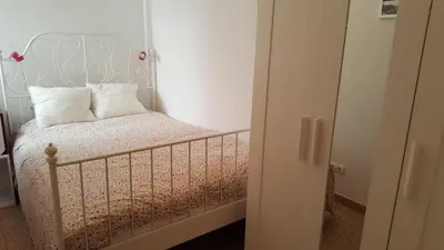 a bedroom with a bed with a white headboard at Apartamento Hector en Sitges in Sitges