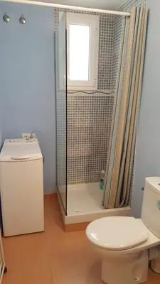 a bathroom with a shower and a toilet and a window at Apartamento Hector en Sitges in Sitges