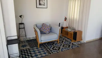 a living room with a chair and a table at The Sky Attic Apartment in Sitges