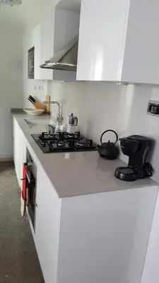 a white kitchen with a stove and a counter top at The Sky Attic Apartment in Sitges