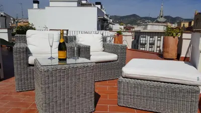 a bottle of wine on a table with chairs on a balcony at The Sky Attic Apartment in Sitges