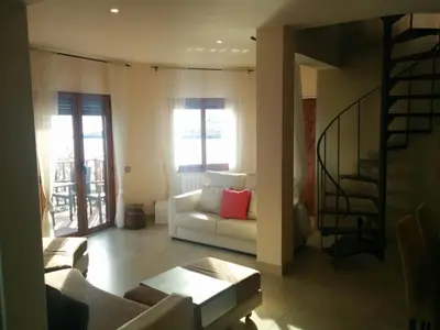 a living room with a white couch and a staircase at Sitges Balcony Pool & Seaside Apartment in Sitges
