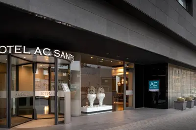 an office lobby with a reception desk and two chairs at AC Hotel Sants by Marriott in Barcelona