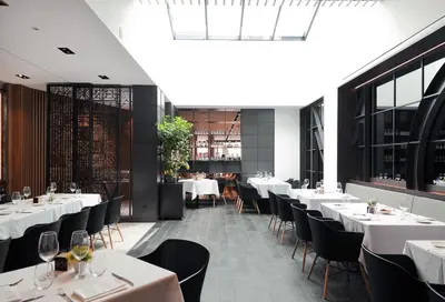 a restaurant with white tables and black chairs at Vila Arenys Hotel in Arenys de Mar