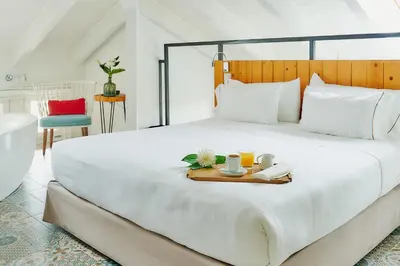 a white bed with a tray of food on it at Hotel Arrey Alella in Alella