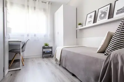 a bedroom with a bed next to a desk and a desk at Residencia Universitaria Resa Barcelona Diagonal in Barcelona
