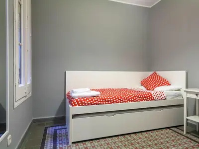 a bed with red and white polka dot sheets and pillows at Apartment in Barcelona near Passeig de Gràcia in Barcelona