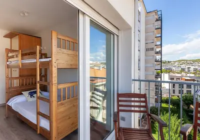 a bedroom with bunk beds and a balcony with a view at Hola! - El Cortijo in Sitges