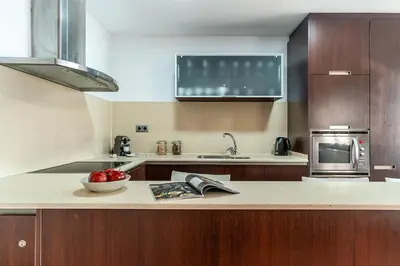 a kitchen with a bowl of fruit on a counter at Enjoybcn Fira Apartment in Barcelona