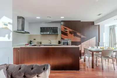 a kitchen and dining room with a table and a couch at Enjoybcn Fira Apartment in Barcelona