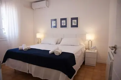 a bedroom with a large white bed with towels on it at New Opening Villa Oasis Terramar in Sitges