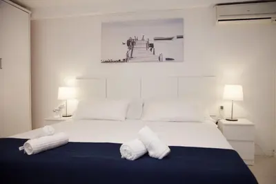 a bedroom with a bed with two white towels on it at New Opening Villa Oasis Terramar in Sitges