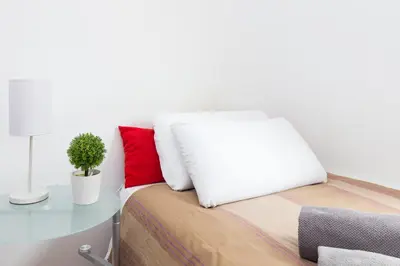 a bed with a white pillow and a table at Key Sagrada Familia - Carrer Del Clot in Barcelona
