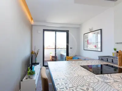 a living room with a dining table and a living room at Attic Terrace Montjuïc in Barcelona