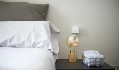 a bed with a white pillow and a lamp on a table at You Stylish Boutique Apartments in Barcelona