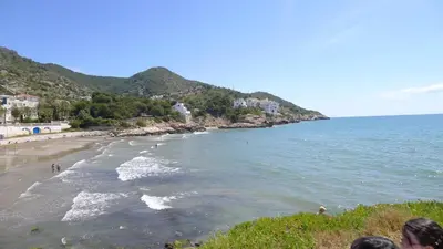 a group of people standing on a beach at Mini Apartamento Port Aiguadolç in Sitges