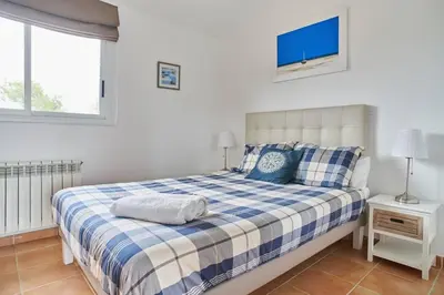 a bedroom with a bed with a blue and white blanket at Casa Garcia in Sitges