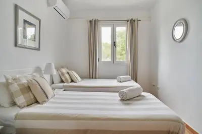 two beds in a white room with a window at Casa Garcia in Sitges