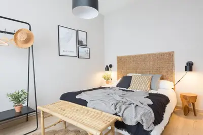 a bedroom with a bed with a wooden headboard at Housalia Familia Rossellon in Barcelona
