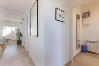 a hallway with a white wall with two pictures on it at Housalia Familia Rossellon in Barcelona