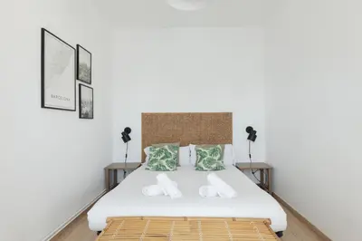a bedroom with a bed and two lamps at Housalia Familia Rossellon in Barcelona