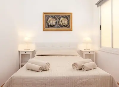 a white bedroom with two beds and two lamps at Rambla Cat · Penthouse with terrace in Barcelona