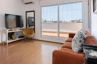 a living room with a couch and a flat screen tv at Rambla Cat · Penthouse with terrace in Barcelona