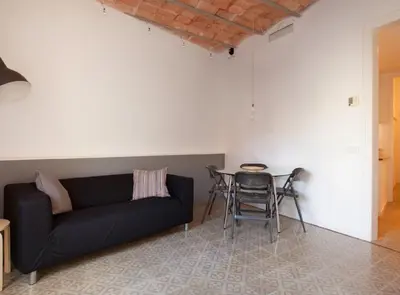 a living room with a black couch and a table at Napoles · Modernist flat close to Sagrada Familia in Barcelona