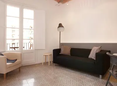 a living room with a black couch and a chair at Napoles · Modernist flat close to Sagrada Familia in Barcelona