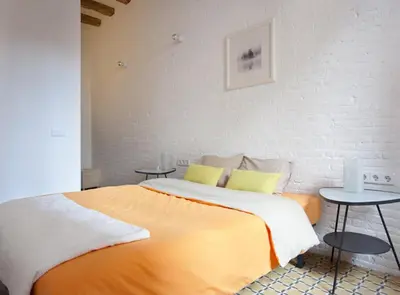 a bedroom with a large bed with two tables at Borrell · Near ramblas in Barcelona