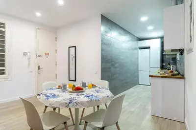 a kitchen and a dining room with a table and chairs at 2215 - AB Calabria Apartment in Barcelona