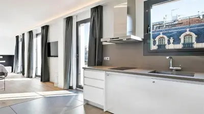 a kitchen with a sink and a large window at Murmuri Residence Mercader in Barcelona