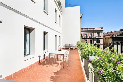 a balcony with a table and chairs on a building at Murmuri Residence Mercader in Barcelona
