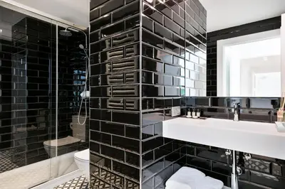 a black bathroom with a sink and a mirror at Murmuri Residence Mercader in Barcelona